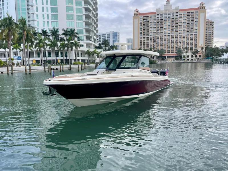 Slide: The Image of 2023 Chris-Craft Calypso 35 boat on calm water near modern buildings. - 2