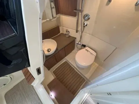 Slide: The Image of 2023 Chris-Craft Calypso 35 boat bathroom with modern fixtures and wooden accents. - 21
