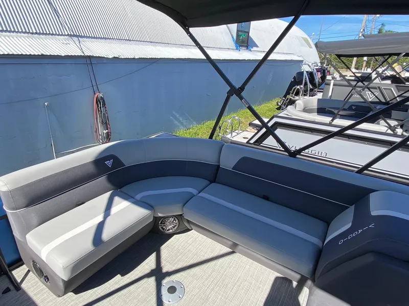 Slide: The Image of 2024 Viaggio Lago 20C pontoon boat with gray seating and canopy, docked outdoors. - 16