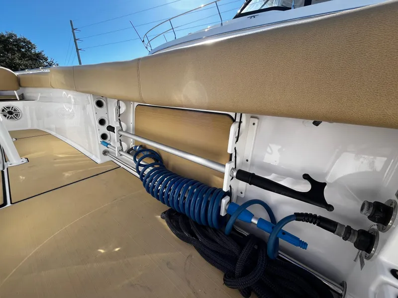 Slide: The Image of 2021 Sportsman Heritage 251 Center Console boat deck with storage and coiled hose. - 13