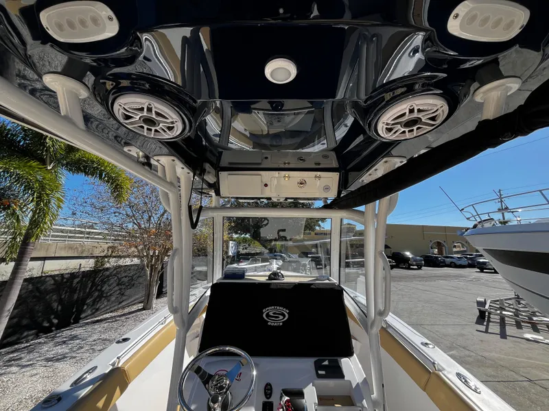 Slide: The Image of 2021 Sportsman Heritage 251 Center Console boat interior with steering wheel and overhead speakers. - 16