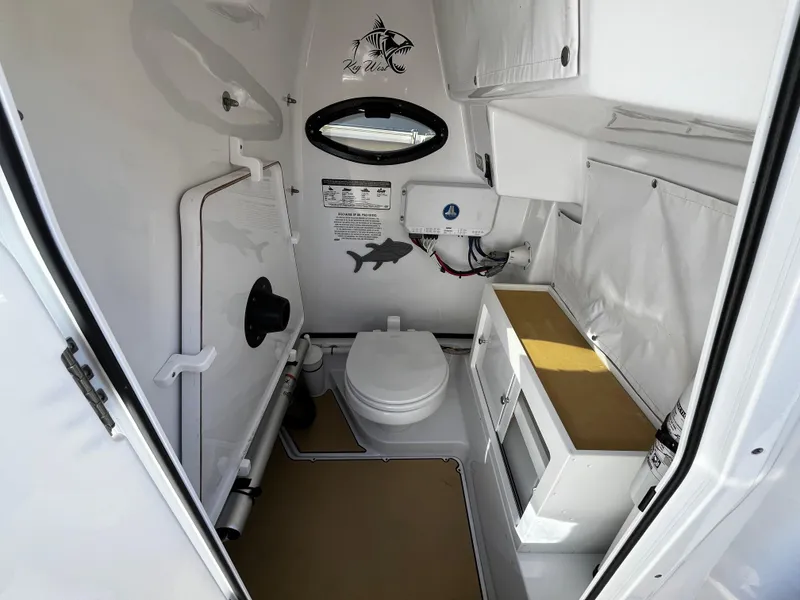 Slide: The Image of 2021 Sportsman Heritage 251 Center Console boat interior bathroom with toilet and storage. - 28
