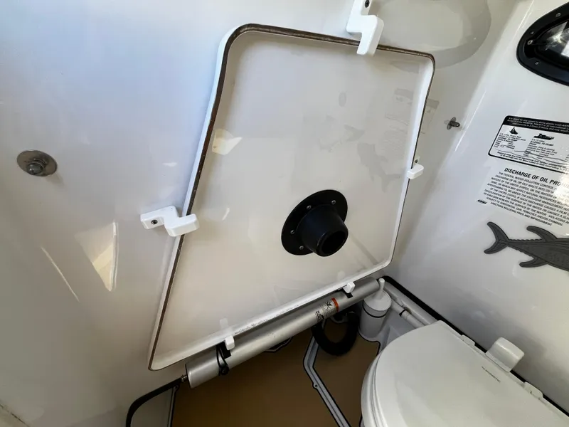 Slide: The Image of 2021 Sportsman Heritage 251 Center Console boat interior with toilet and storage compartment. - 29