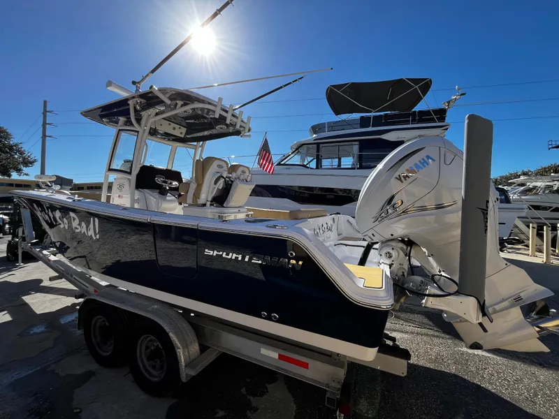 Slide: The Image of 2021 Sportsman Heritage 251 Center Console boat on trailer, docked with other boats. - 3