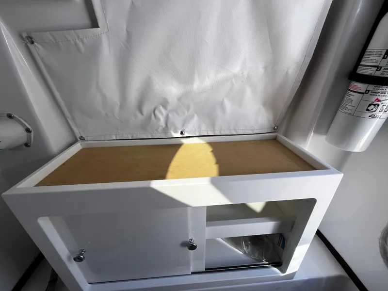 Slide: The Image of 2021 Sportsman Heritage 251 Center Console storage compartment with fire extinguisher. - 30