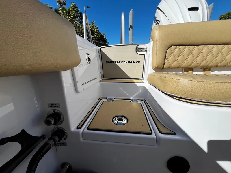 Slide: The Image of 2021 Sportsman Heritage 251 Center Console boat interior, featuring tan seating and storage compartments. - 7