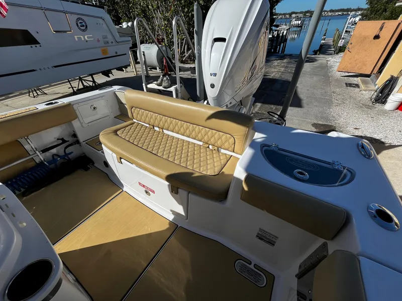Slide: The Image of 2021 Sportsman Heritage 251 Center Console boat interior with tan seating and Yamaha outboard motor. - 9