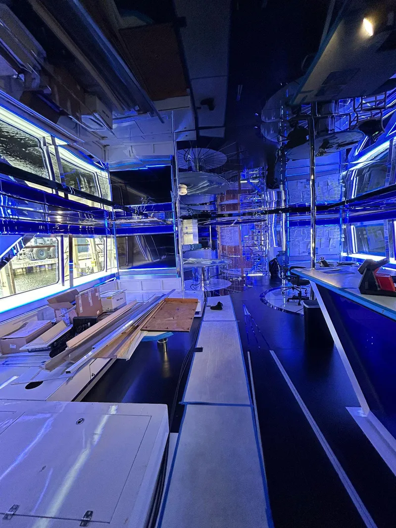 Slide: The Image of Interior of 1992 Heesen 141 Motor Yacht with modern blue lighting and sleek design elements. - 13