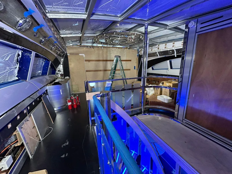 Slide: The Image of Interior renovation of a 1992 Heesen 141 Motor Yacht with blue lighting and construction materials. - 30