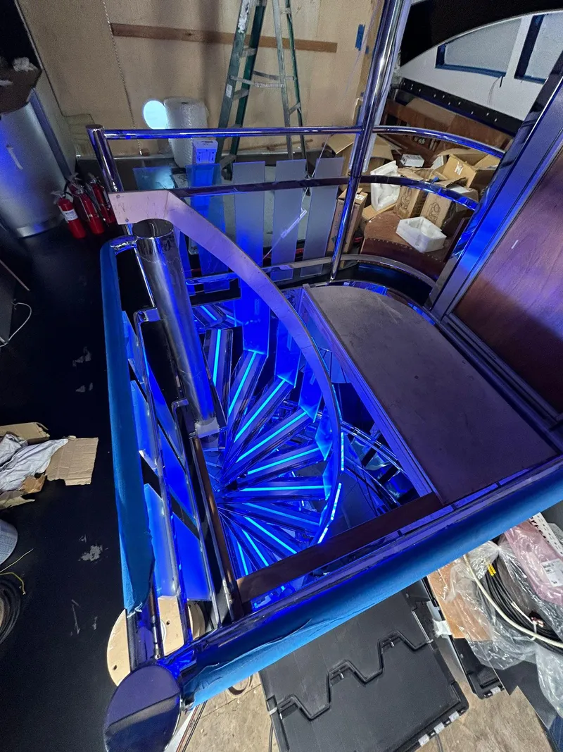 Slide: The Image of Illuminated spiral staircase on 1992 Heesen 141 Motor Yacht, featuring modern blue lighting. - 31