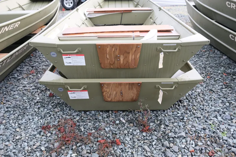 Slide: The Image of 2024 Crestliner 1436L CR Jon boats stacked on gravel lot. - 3
