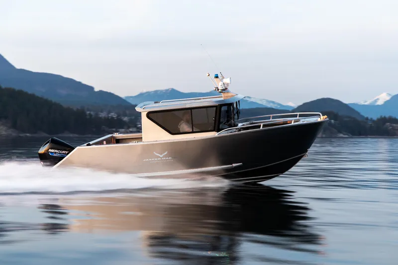 Slide: The Image of 2025 Jasper Marine Defender 22 cruising on a serene lake with mountainous backdrop. - 14