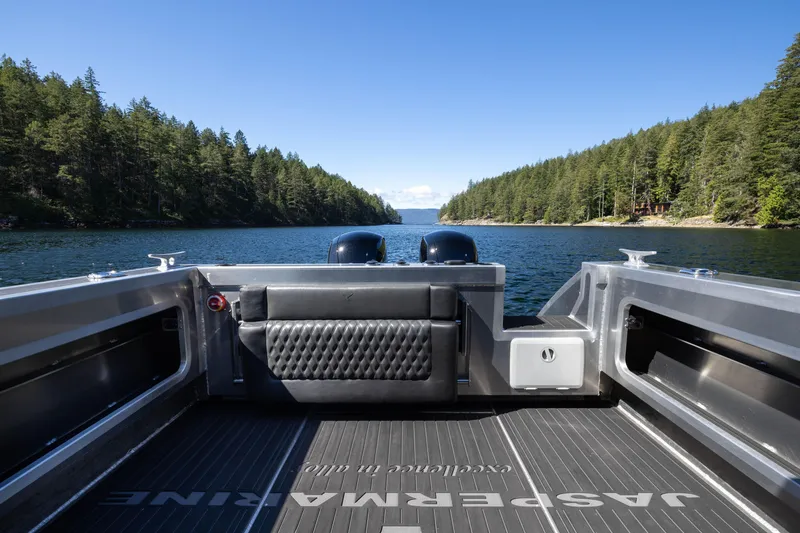 Slide: The Image of 2025 Jasper Marine Defender 22 boat on scenic lake with forested shoreline. - 27