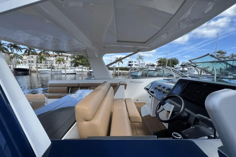 Slide: The Image of 2024 Aviara AV40 Outboard interior with luxurious seating and modern dashboard, docked at marina. - 18