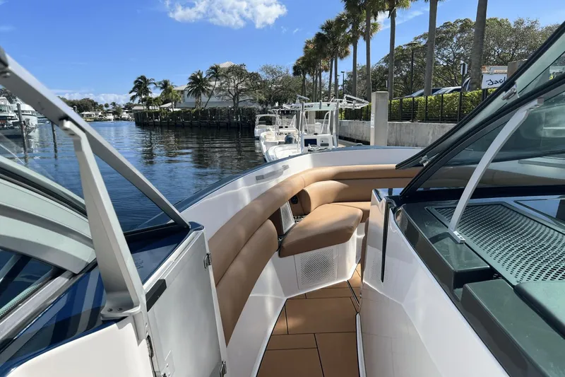 Slide: The Image of 2024 Aviara AV40 Outboard boat interior with tan seating, docked by palm trees. - 24