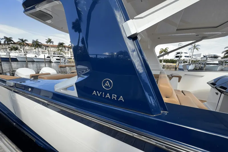 Slide: The Image of 2024 Aviara AV40 Outboard luxury boat docked, featuring sleek blue and white design. - 27