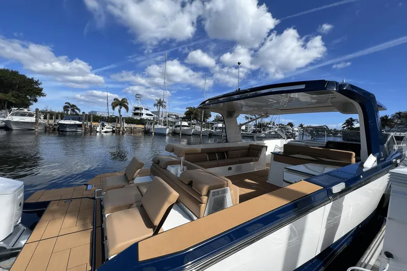 Slide: The Image of 2024 Aviara AV40 Outboard luxury boat docked at marina under blue sky. - 5