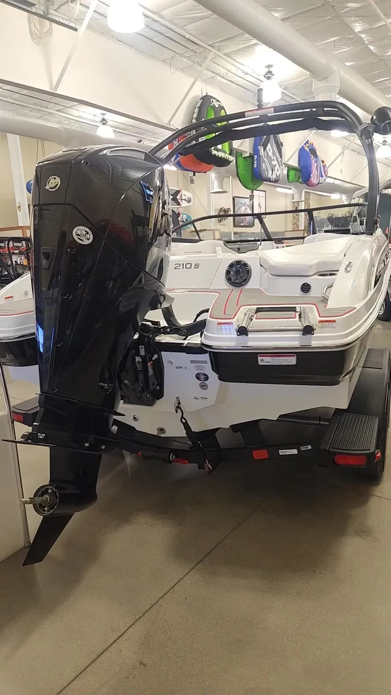 Slide: The Image of 2024 Tahoe 210 S boat with outboard motor in showroom. - 2
