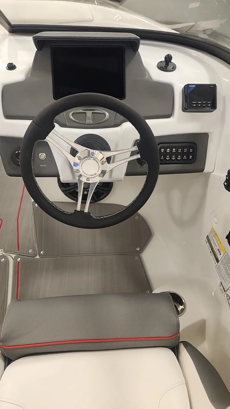Slide: The Image of 2024 Tahoe 210 S boat dashboard with steering wheel and control panel. - 6