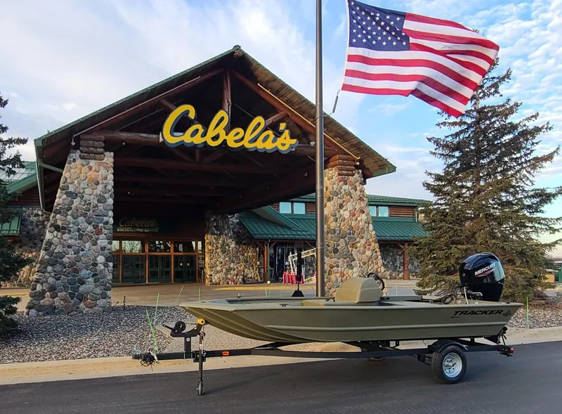 The Image of 2024 Tracker Grizzly 1648 SC boat outside Cabela's store with American flag. - 0