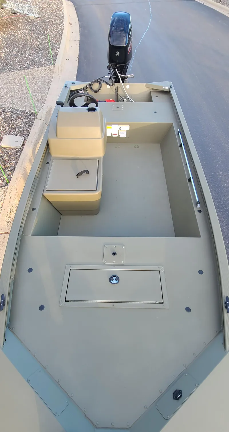 Slide: The Image of 2024 Tracker Grizzly 1648 SC boat, beige interior, outboard motor, spacious seating. - 7