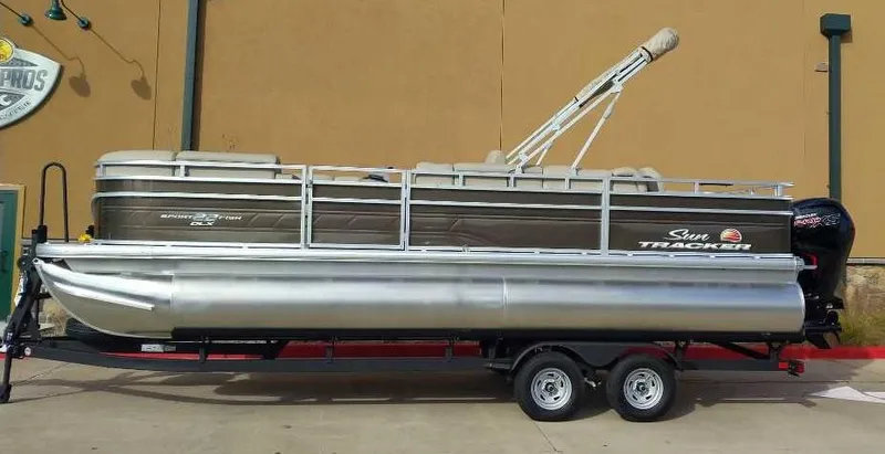 The Image of 2024 Sun Tracker SportFish 22 DLX pontoon boat on a trailer. - 0