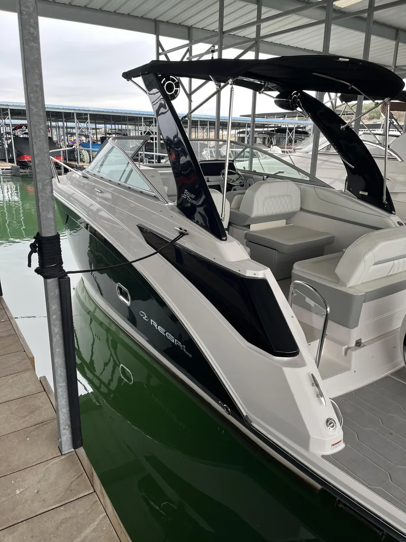 The Image of 2022 Regal 26XO boat docked in marina, featuring sleek design and comfortable seating. - 1