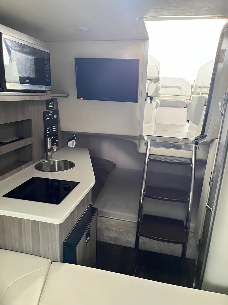 Slide: The Image of Interior of 2022 Regal 26XO boat with kitchenette and seating area. - 16