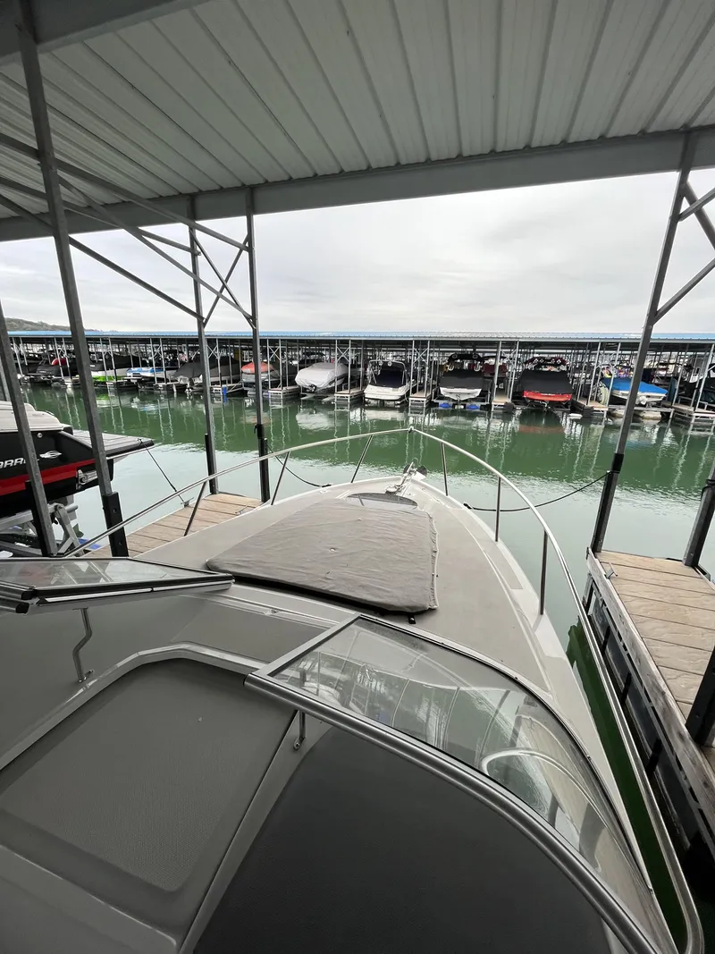 Slide: The Image of 2022 Regal 26XO boat docked in a marina with covered slips. - 19