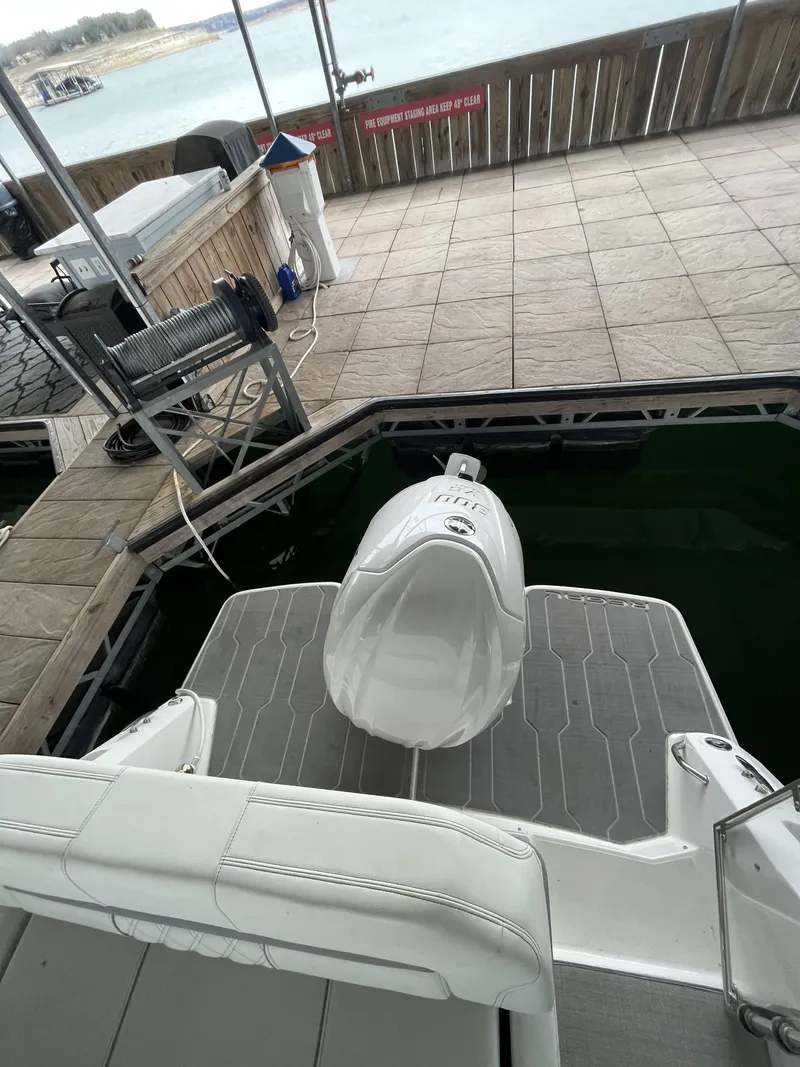 Slide: The Image of 2022 Regal 26XO boat docked, featuring a sleek outboard motor and spacious deck. - 20