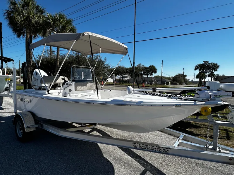 Slide: The Image of 2024 Sea Pro 172 Bay boat on trailer, parked outdoors under clear blue sky. - 3