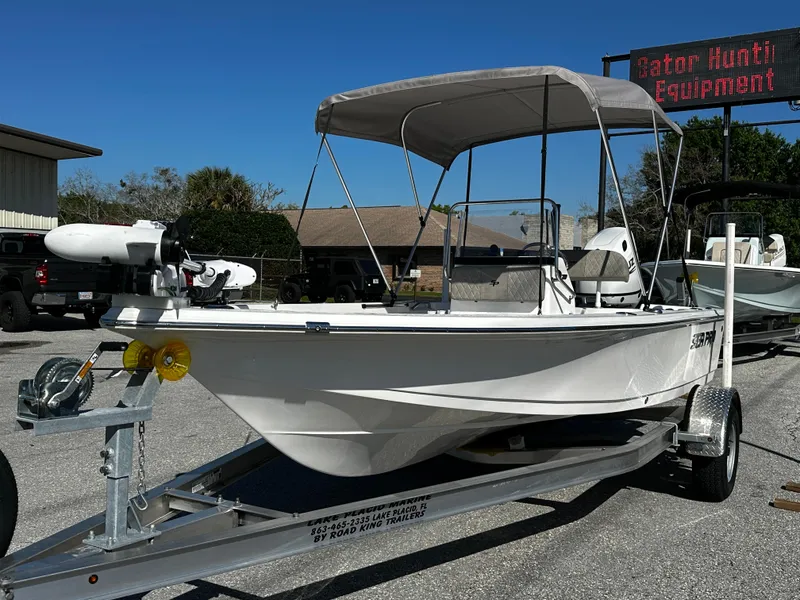 Slide: The Image of 2024 Sea Pro 172 Bay boat on trailer with canopy, parked outdoors. - 4