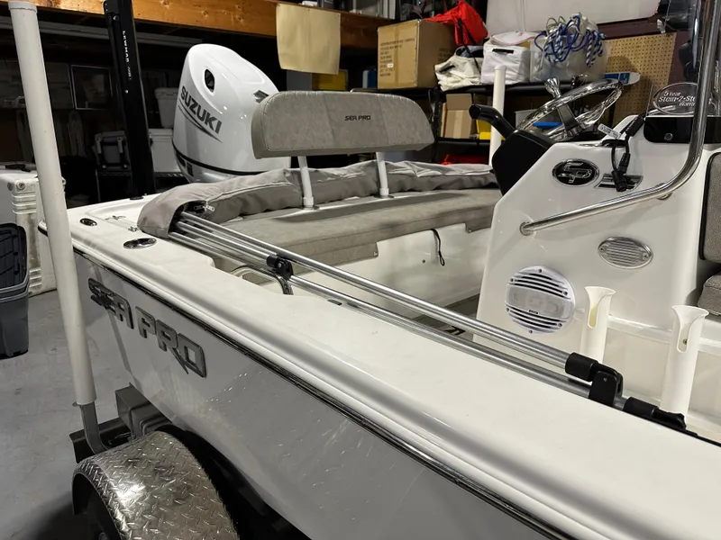 Slide: The Image of 2024 Sea Pro 172 Bay boat in a garage, featuring a Suzuki outboard motor. - 5