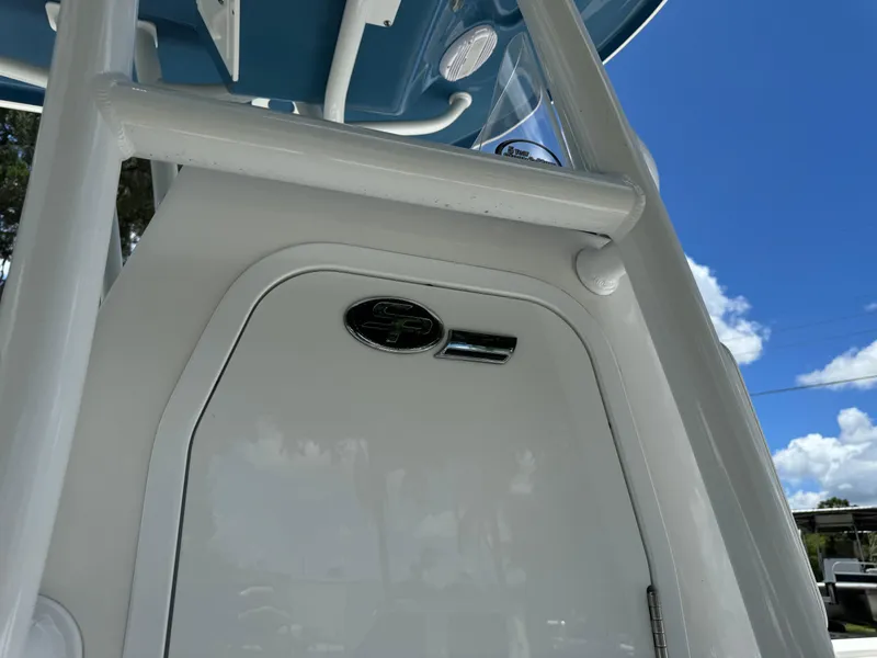 Slide: The Image of 2024 Sea Pro 230 Bay boat console with blue canopy and clear sky background. - 20