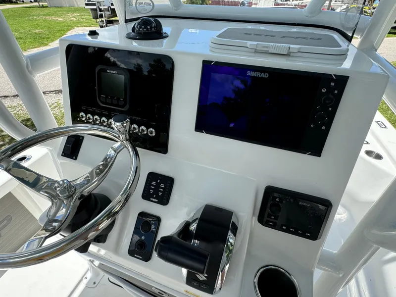 Slide: The Image of 2024 Sea Pro 230 Bay boat dashboard with steering wheel, controls, and navigation screens. - 28