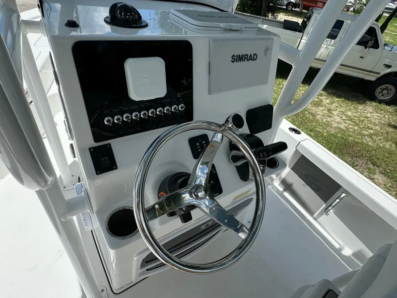 Slide: The Image of 2024 Sea Pro 230 Bay boat helm with Simrad electronics and stainless steel steering wheel. - 29