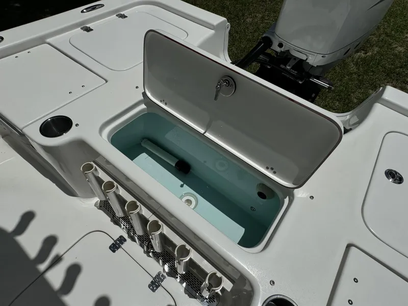 Slide: The Image of 2024 Sea Pro 230 Bay boat with open storage compartment and rod holders. - 41