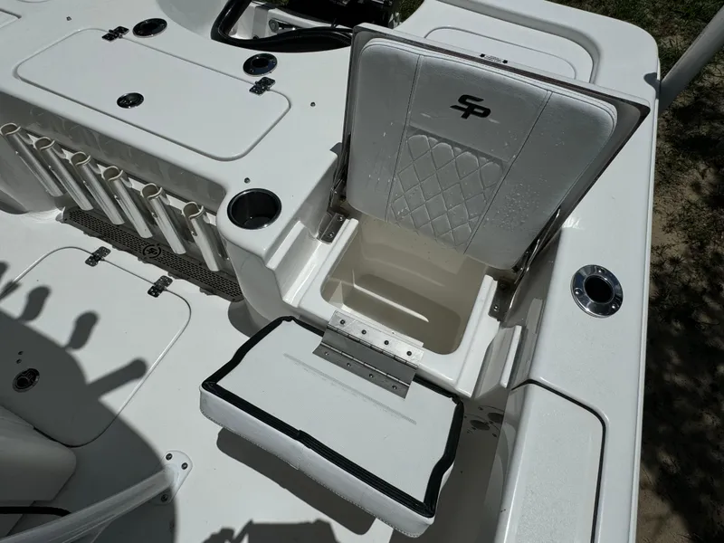 Slide: The Image of 2024 Sea Pro 230 Bay boat interior with open storage compartment and rod holders. - 43