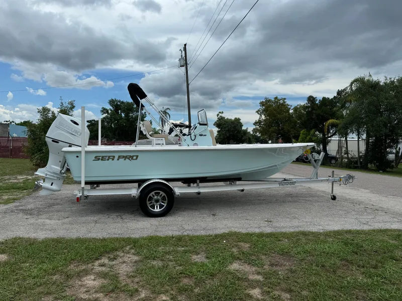 Slide: The Image of 2024 Sea Pro 210 Bay boat on a trailer under a cloudy sky. - 0
