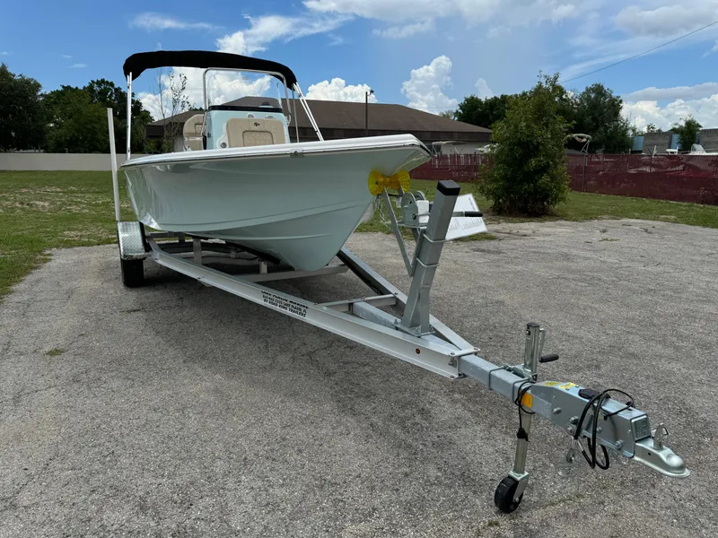 Slide: The Image of 2024 Sea Pro 210 Bay boat on a trailer in a parking lot. - 1