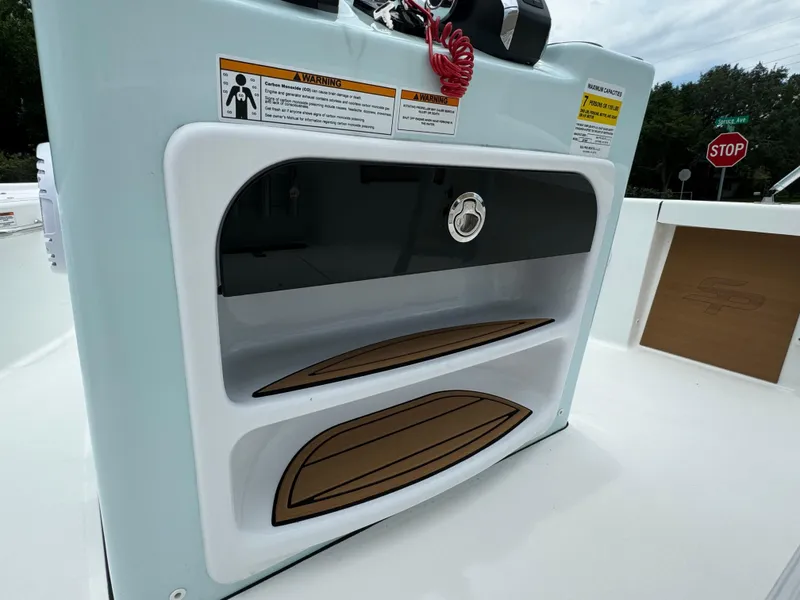 Slide: The Image of 2024 Sea Pro 210 Bay boat storage compartment with wood accents. - 19
