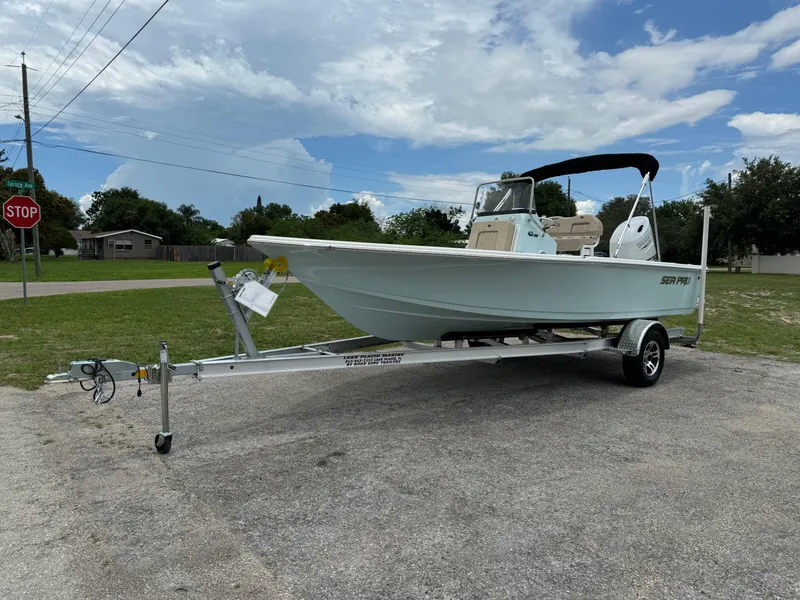 Slide: The Image of 2024 Sea Pro 210 Bay boat on a trailer in a suburban area. - 2