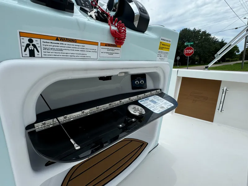Slide: The Image of 2024 Sea Pro 210 Bay boat console with storage compartment and safety warnings. - 20