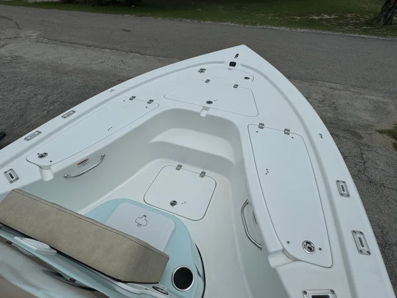 Slide: The Image of 2024 Sea Pro 210 Bay boat bow with storage compartments and seating. - 4