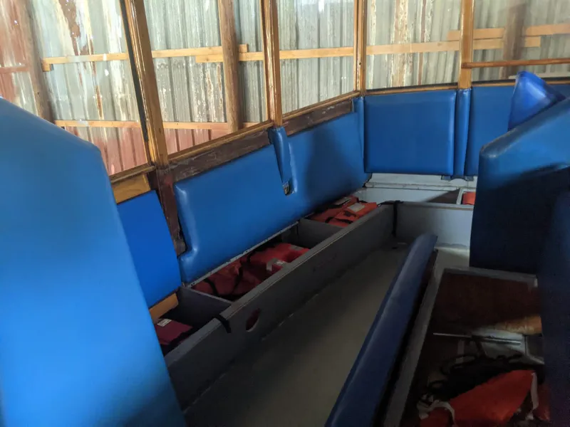 Slide: The Image of Interior of a 1987 Custom tour boat with blue seating and life jackets. - 10