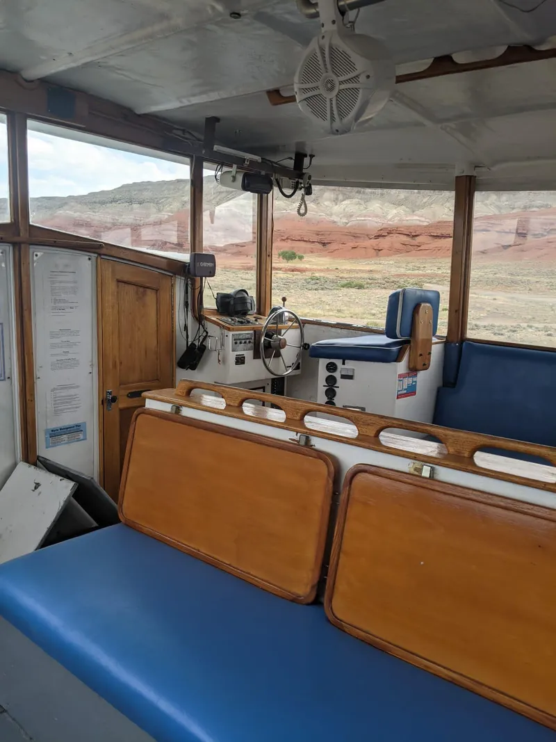 Slide: The Image of Interior of a 1987 custom tour boat with blue seating and wooden accents. - 13