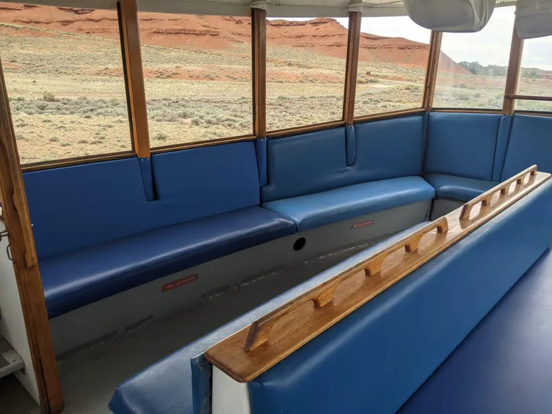 Slide: The Image of Interior of a 1987 custom tour boat with blue seating and scenic window views. - 15