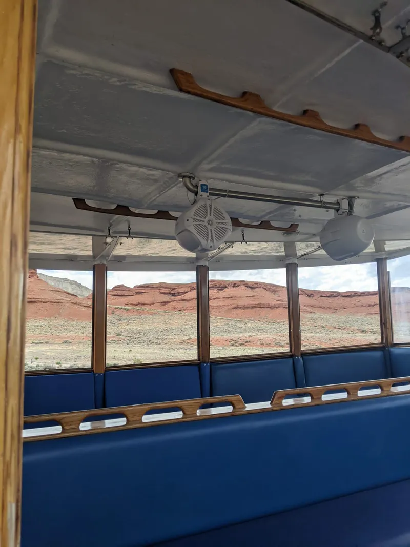 Slide: The Image of Interior of a 1987 custom tour boat with blue seating and scenic desert view. - 17