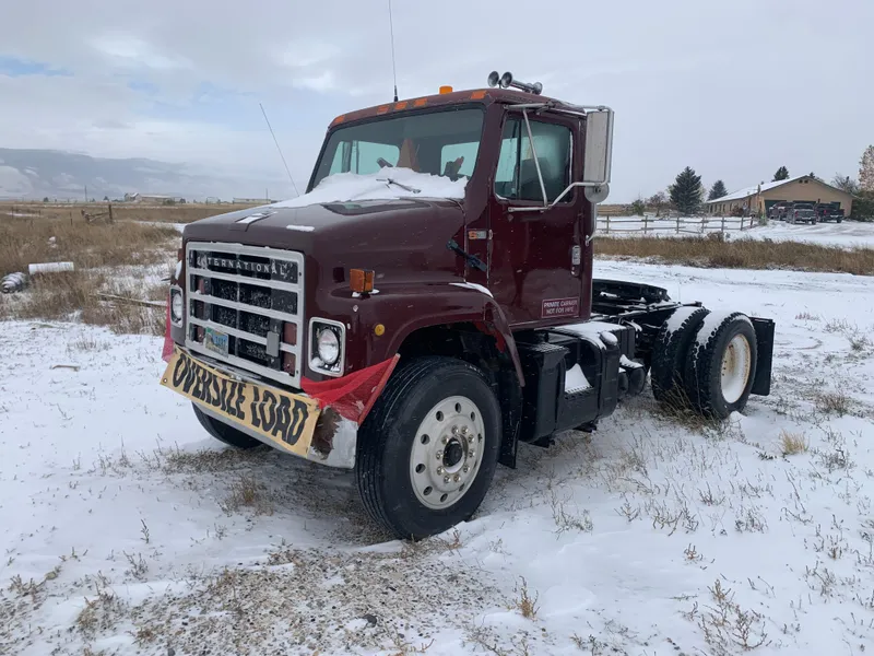 Slide: The Image of Red 1987 Custom Tour Boat and Business truck in snowy field with Oversize Load sign. - 25