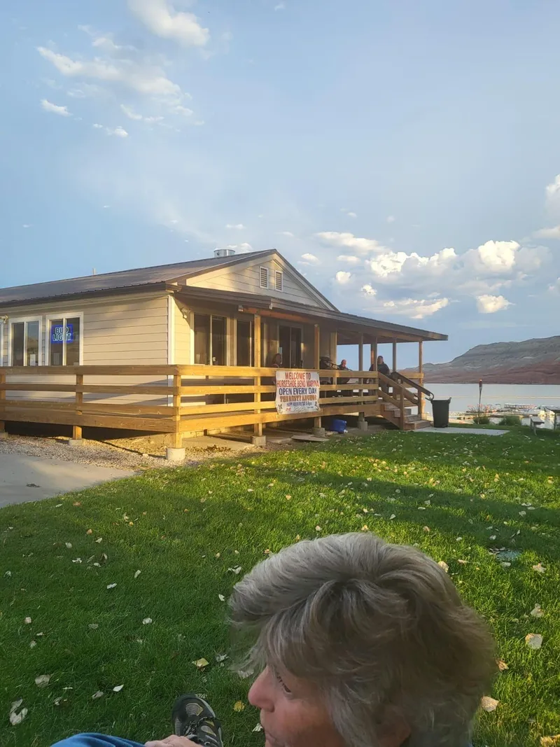 Slide: The Image of Tour boat business building with wooden deck, green lawn, and lake view. - 34